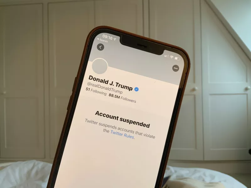 A smartphone with the banned account of Donald Trump on screen.